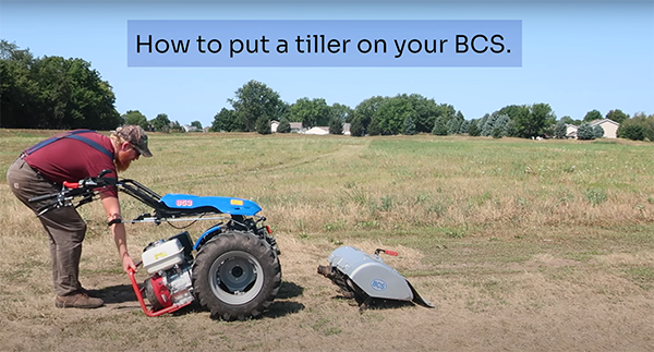 Side view of a farmer attaching a tiller to BCS machine