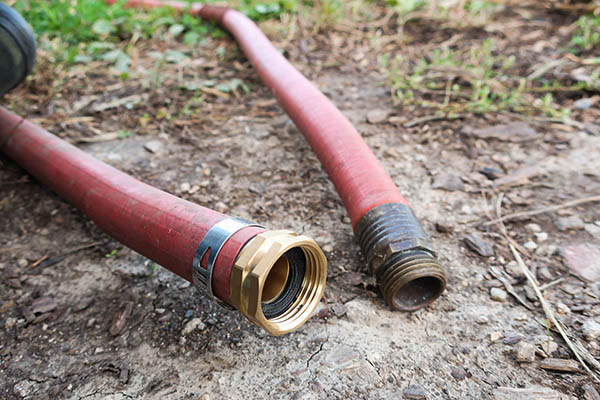 Two ends of a garden hose, one with a new fitting and the other with an old fitting.