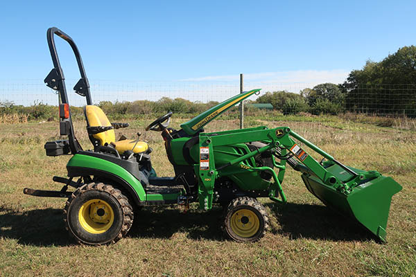 A green tractor from the side view.