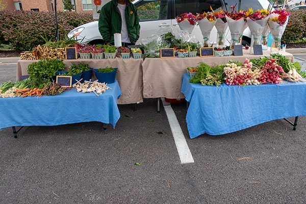 Farmers market display with higher and lower tables makes it easy for customers to see produce.