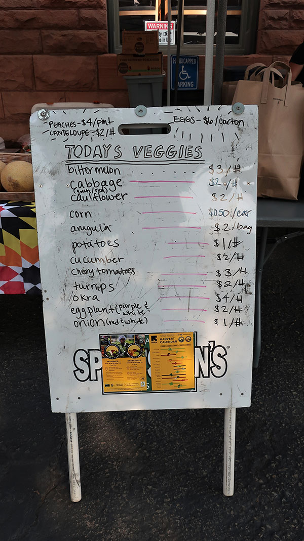 A white handwritten sandwich board says